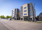 Thumbnail 2 of 16 - A street view of a residential area with apartment buildings.