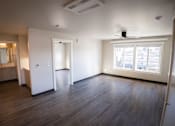 Thumbnail 11 of 16 - A room with wooden floors and a window with a view of buildings outside.