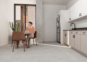 Thumbnail 7 of 30 - A man is sitting at a table in a modern kitchen.