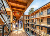 Thumbnail 28 of 41 - A family is standing on a wooden deck between two buildings.