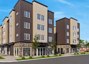 Thumbnail 1 of 16 - A modern apartment building with a sign for Wheel Deal Bicycles in front.