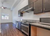 Thumbnail 9 of 10 - a kitchen with granite countertops and stainless steel appliances
