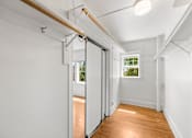 Thumbnail 19 of 35 - A room with white walls and wooden flooring with a sliding door.