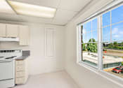 Thumbnail 27 of 35 - A kitchen with white appliances and cabinets is shown.
