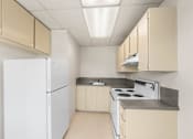 Thumbnail 32 of 35 - A kitchen with white appliances and beige cabinets.