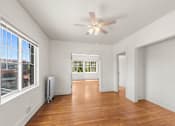 Thumbnail 29 of 35 - A room with a ceiling fan and a window overlooking a cityscape.