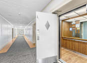 Thumbnail 26 of 35 - A long hallway with a white door at the end.