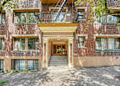 Thumbnail 1 of 35 - A red brick building with a balcony and a staircase leading to the entrance.