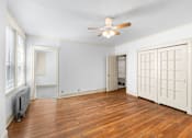 Thumbnail 6 of 35 - A room with a ceiling fan and wooden floors.