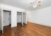 Thumbnail 7 of 35 - A room with a ceiling fan and wood flooring.