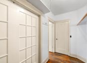 Thumbnail 11 of 35 - A hallway with a white door and a white wall.