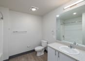 Thumbnail 36 of 38 - A white bathroom with a toilet, sink, and mirror.