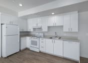 Thumbnail 37 of 38 - A white kitchen with a refrigerator, stove, oven, and sink.