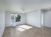 Thumbnail 10 of 38 - A room with a ceiling fan and a window with a view of trees and a trash can.