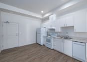 Thumbnail 28 of 38 - A kitchen with white cabinets and appliances.