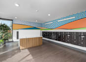 Thumbnail 15 of 38 - A modern office with a wooden reception desk and a wall of lockers.