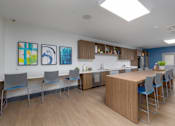 Thumbnail 17 of 38 - A kitchen with a table and chairs and a painting on the wall.