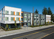 Thumbnail 34 of 38 - A row of modern townhouses with a clear blue sky above.