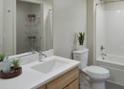 Thumbnail 30 of 35 - A white toilet sits next to a sink in a bathroom.