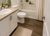 Thumbnail 20 of 21 - A white bathroom with a toilet, sink, and shower.
