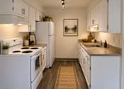 Thumbnail 16 of 21 - A kitchen with white appliances and cabinets.