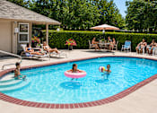 Thumbnail 21 of 21 - People are enjoying their time in the pool with inflatable rings.