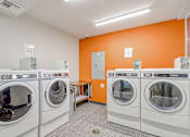 Thumbnail 7 of 21 - A row of washing machines in a laundromat.
