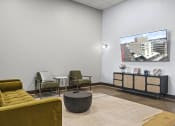 Thumbnail 75 of 76 - a lounge area with couches chairs and a coffee table with a flat screen tv on the  at The Icon, Richmond, VA 23230