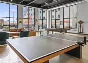 Thumbnail 69 of 76 - a ping pong table sits in the middle of a room with large windows  at The Icon, Richmond, VA, 23230