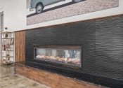 Thumbnail 53 of 76 - a fireplace with a wooden mantle and a painting of a car on the wall above it  at The Icon, Richmond, VA 23230