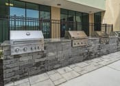 Thumbnail 29 of 76 - a retaining wall with three grills in front of a building at The Icon, Richmond, VA 23230