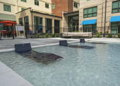 Thumbnail 37 of 76 - a pool with lounge chairs and umbrellas in front of a building at The Icon, Richmond, VA 23230