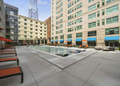 Thumbnail 45 of 76 - a pool area with lounge chairs and umbrellas in front of a tall building  at The Icon, Richmond, VA 23230