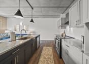 Thumbnail 25 of 76 - a kitchen with white cabinets and gray countertops at The Icon, Richmond, VA 23230