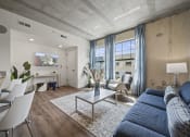 Thumbnail 66 of 76 - a living room with a blue couch and a white coffee table  at The Icon, Richmond, VA 23230