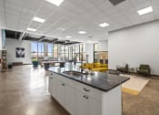 Thumbnail 43 of 76 - a large open space with a kitchen island and yellow couches  at The Icon, Richmond, VA 23230