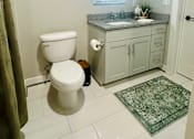 Thumbnail 11 of 18 - A bathroom with a toilet, sink, and mirror.