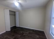 Thumbnail 24 of 28 - an empty living room with wood floors and a ceiling fan
