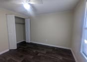 Thumbnail 20 of 33 - an empty living room with wood floors and a ceiling fan