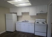 Thumbnail 16 of 33 - a kitchen with white cabinets and appliances and a white refrigerator