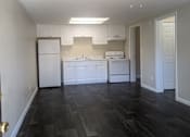 Thumbnail 16 of 32 - an empty kitchen with white cabinets and a ceiling fan