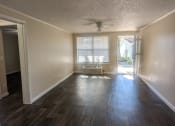 Thumbnail 17 of 33 - an empty living room with wood floors and a window