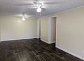 Thumbnail 18 of 32 - an empty living room with wood flooring and a ceiling fan