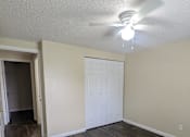 Thumbnail 25 of 32 - an empty living room with wood flooring and a ceiling fan