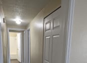 Thumbnail 27 of 33 - a hallway with white doors and a wood flooring in a home