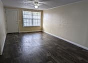 Thumbnail 17 of 32 - an empty living room with wood floors and a window