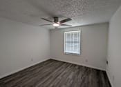 Thumbnail 18 of 25 - A room with a ceiling fan and a window with blinds.