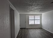 Thumbnail 11 of 25 - A room with a door and a window with blinds.