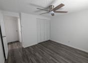 Thumbnail 24 of 25 - A room with a ceiling fan and wood flooring.