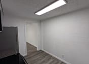 Thumbnail 16 of 25 - A kitchen with a black stove top oven and a white wall.